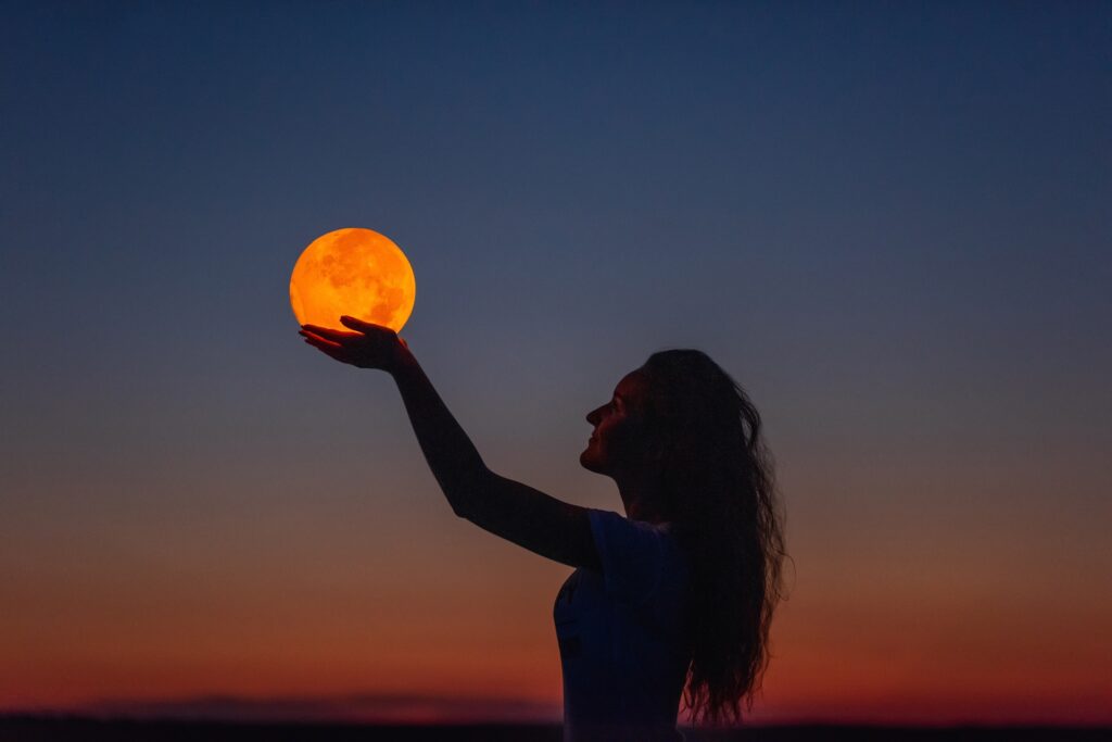 Молодая девушка, держащая в руках полную Луну